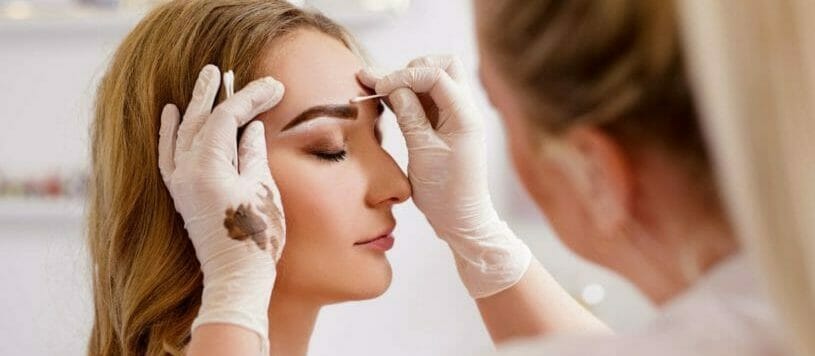 Woman receiving eyebrow tinting services.