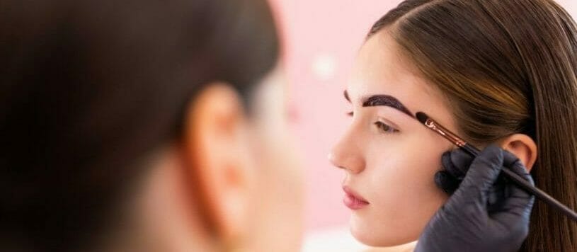 Woman receiving brow tinting services.