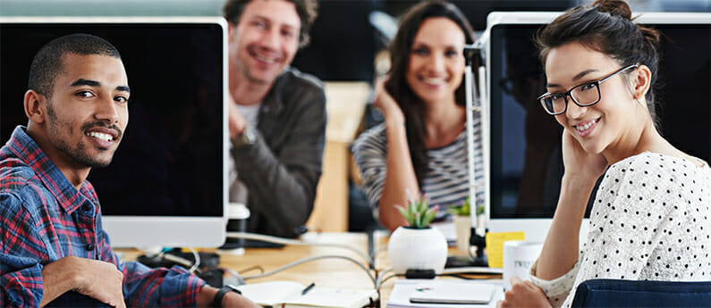 Portrait of a group of young office workers sitting at their computers