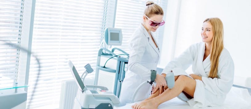 Female client receiving a laser hair removal treatment on her legs.